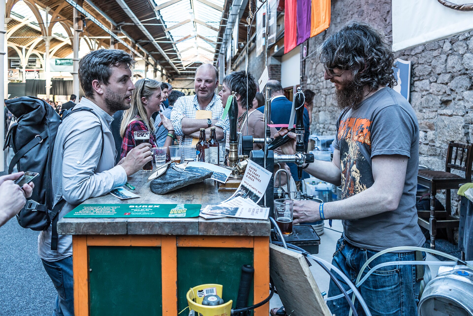 Brewers serving guests at a busy craft beer festival stand
