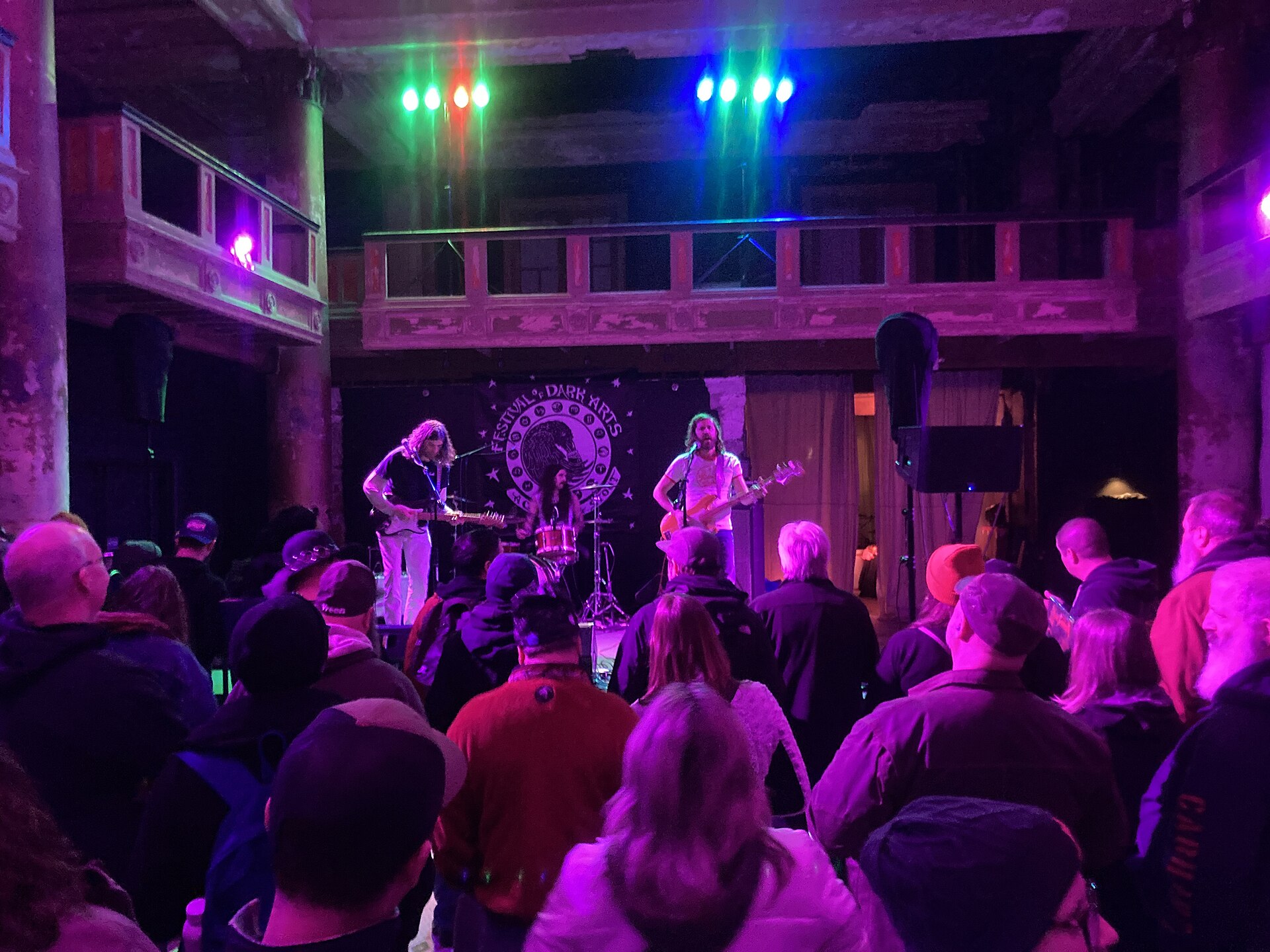 A festival crowd watching live music in a brewery courtyard