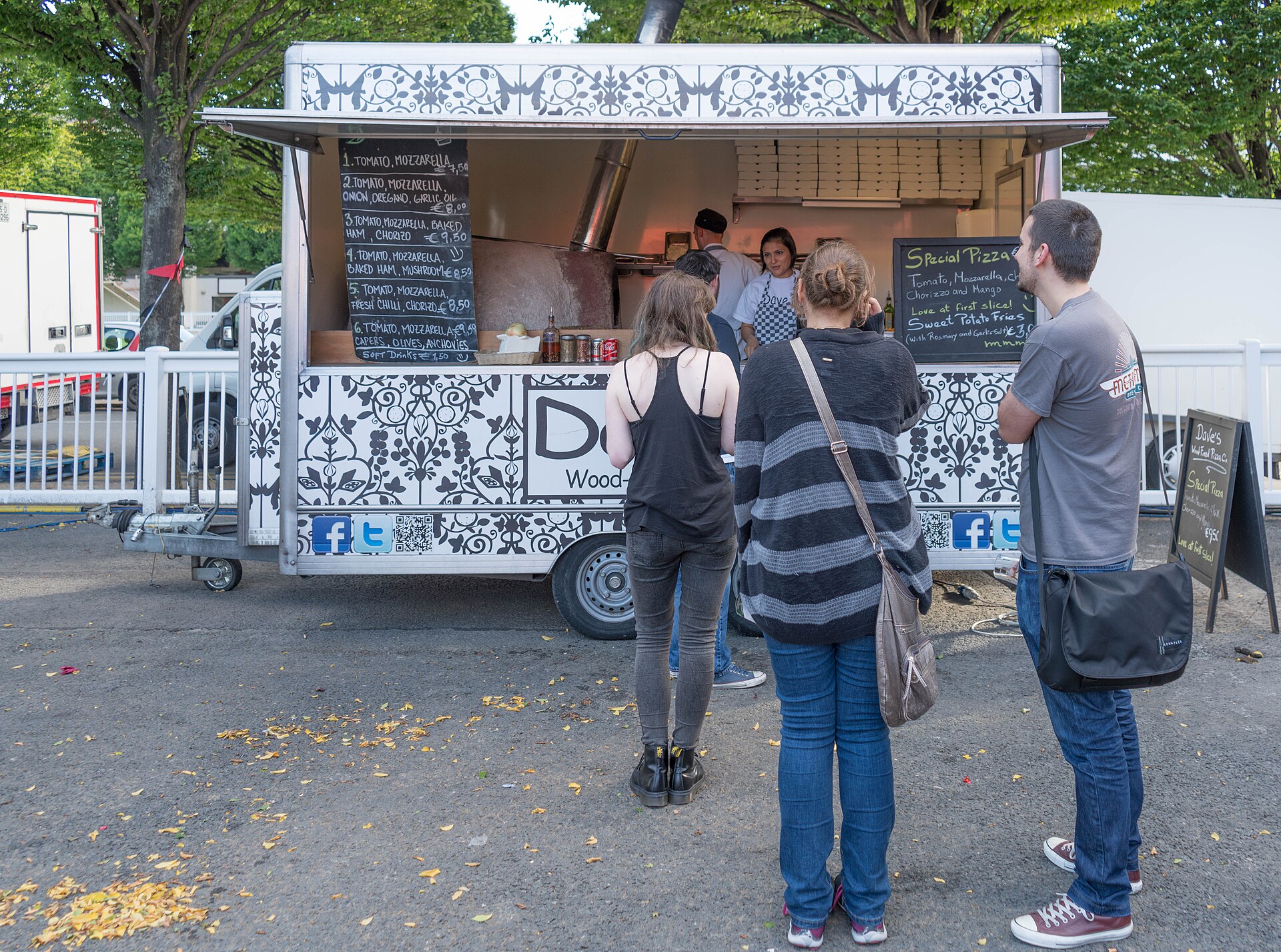 Festival guests walking between outdoor food and drink stands