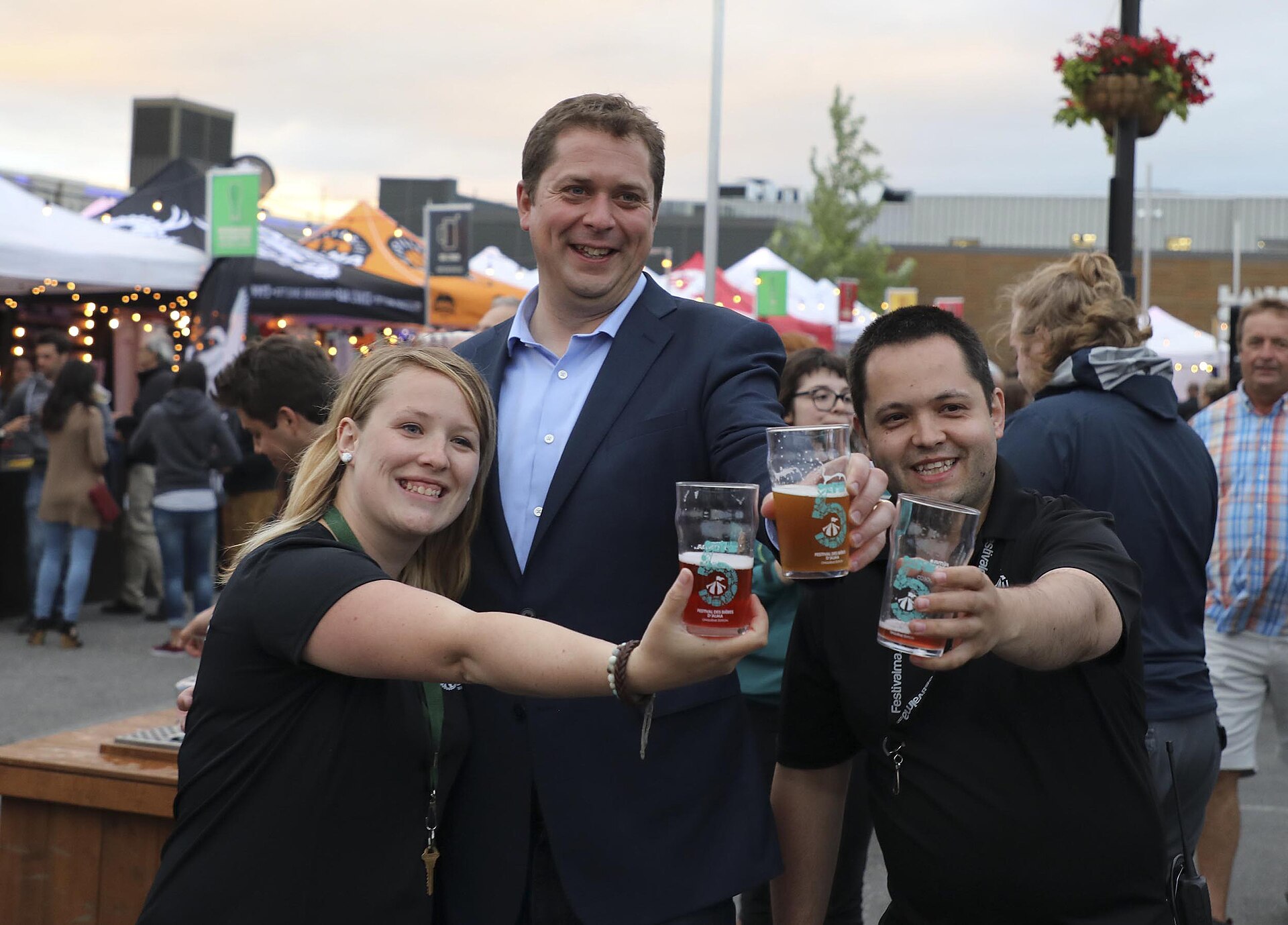 Festival guests raising tasting glasses at a Quebec beer festival